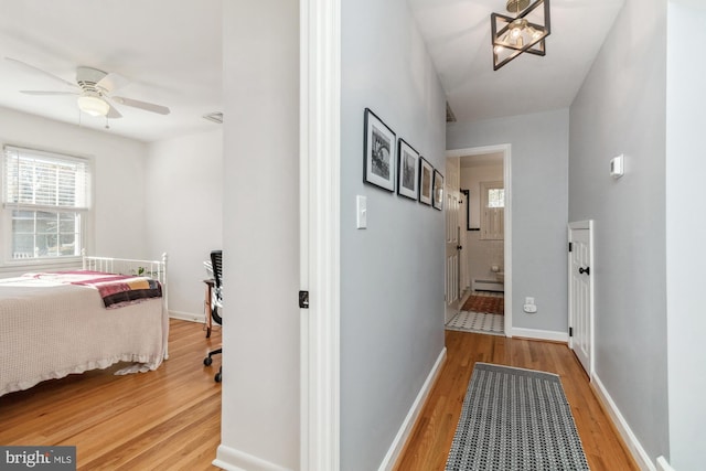 corridor with a baseboard radiator and hardwood / wood-style flooring