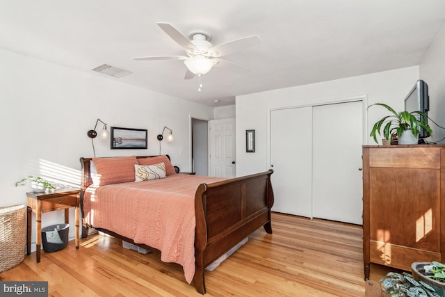 bedroom with ceiling fan, light hardwood / wood-style floors, and a closet