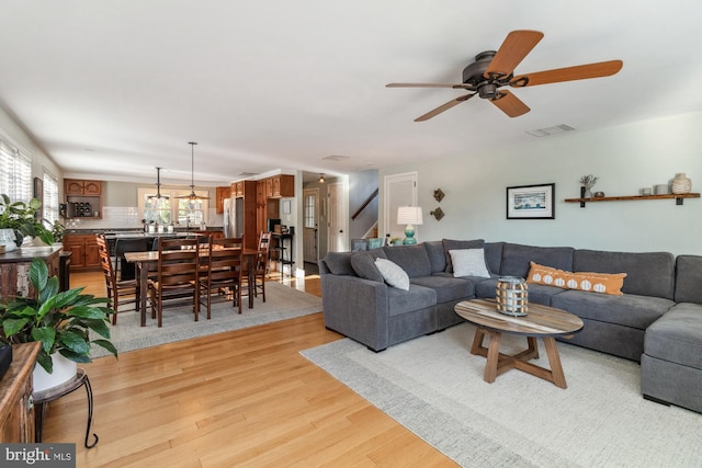 living room with ceiling fan and light wood-type flooring