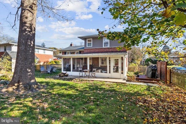 rear view of property with a sunroom and a yard