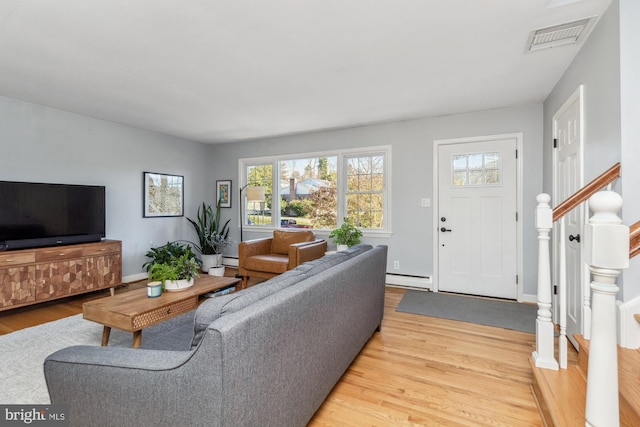 living room with light wood-type flooring and baseboard heating