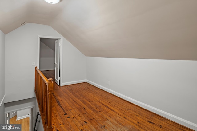 bonus room with hardwood / wood-style floors and vaulted ceiling