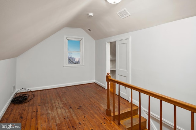 bonus room with lofted ceiling and dark wood-type flooring