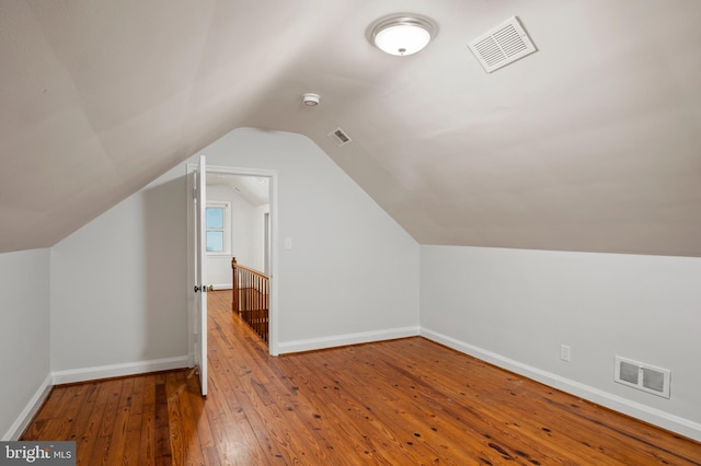 additional living space with vaulted ceiling and hardwood / wood-style flooring