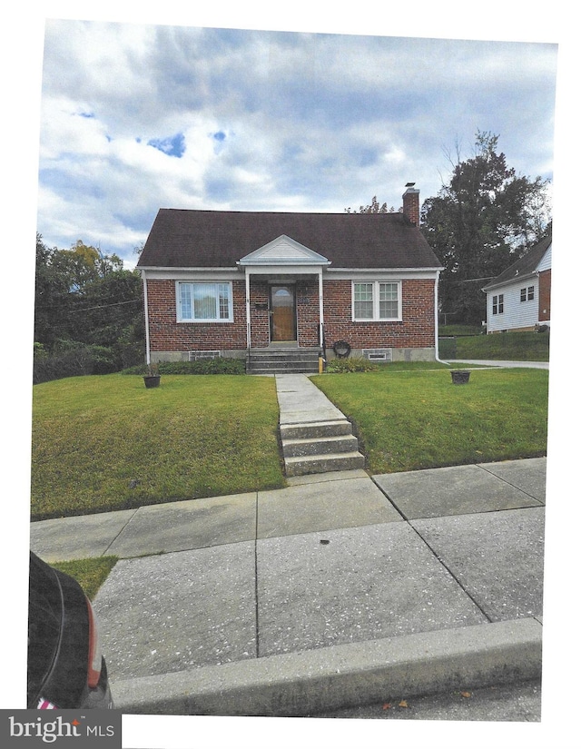 bungalow-style home with a front yard