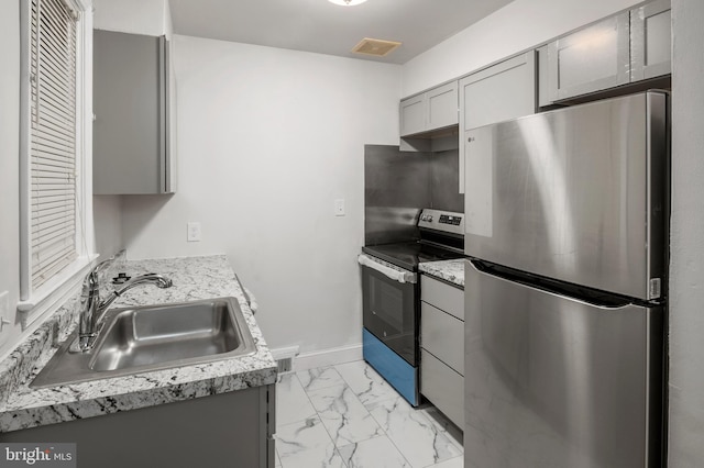 kitchen featuring gray cabinetry, sink, and appliances with stainless steel finishes