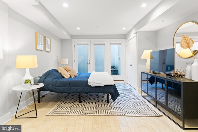 bedroom with light hardwood / wood-style floors, access to exterior, and french doors