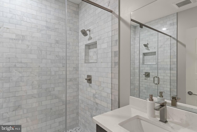 bathroom with vanity and a shower with shower door