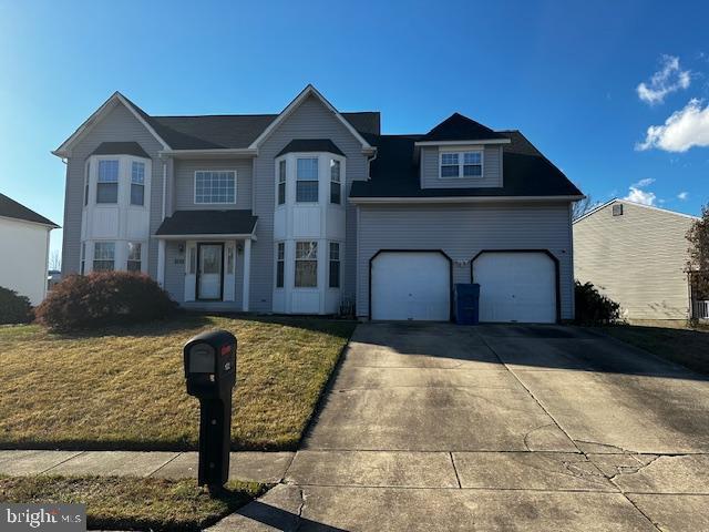 view of front of home with a garage and a front lawn