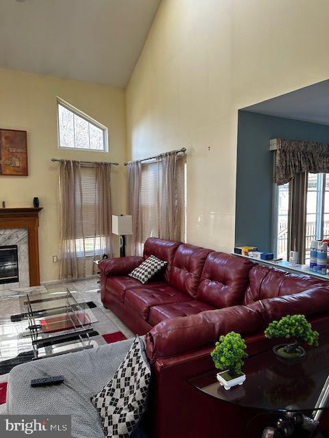 living room featuring a high end fireplace and high vaulted ceiling