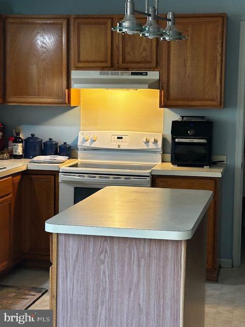 kitchen with electric range, a kitchen island, and a chandelier