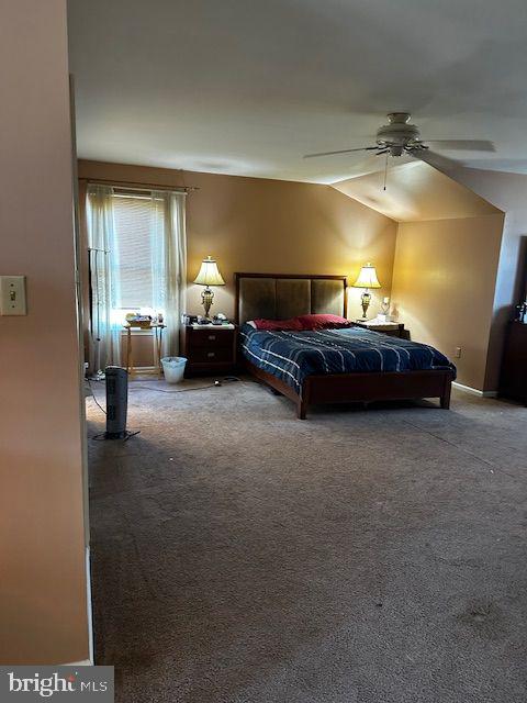 carpeted bedroom featuring ceiling fan and vaulted ceiling