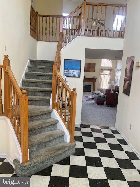 staircase with carpet floors and a high ceiling