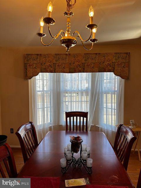 dining area featuring hardwood / wood-style floors and an inviting chandelier