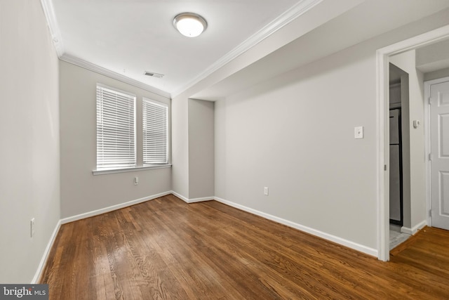 empty room with hardwood / wood-style floors and ornamental molding