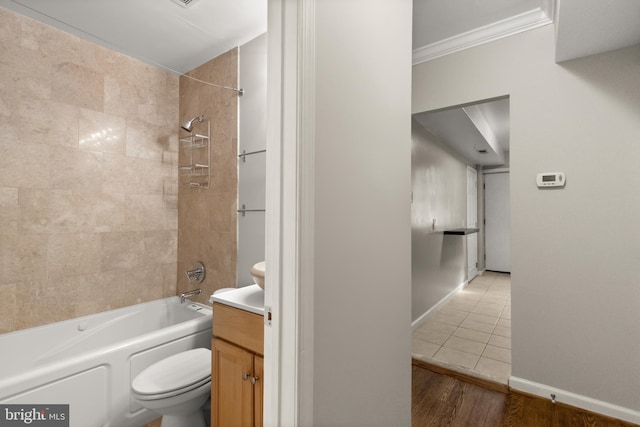 full bathroom featuring ornamental molding, vanity, tiled shower / bath combo, hardwood / wood-style floors, and toilet