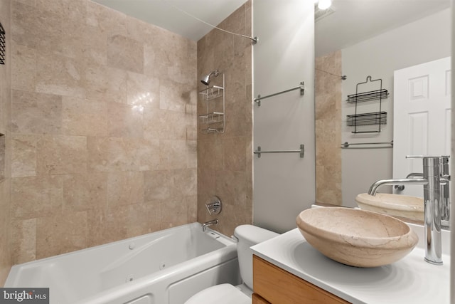 full bathroom with vanity, tiled shower / bath combo, and toilet