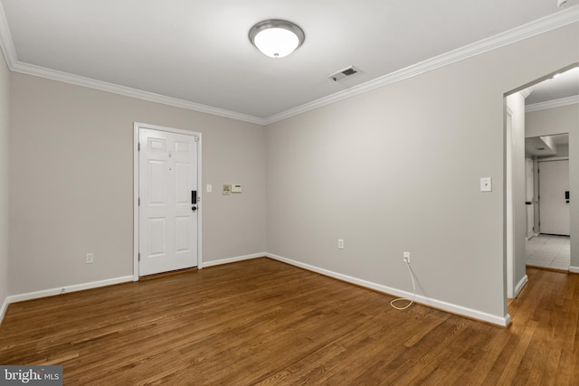 empty room featuring hardwood / wood-style floors and ornamental molding