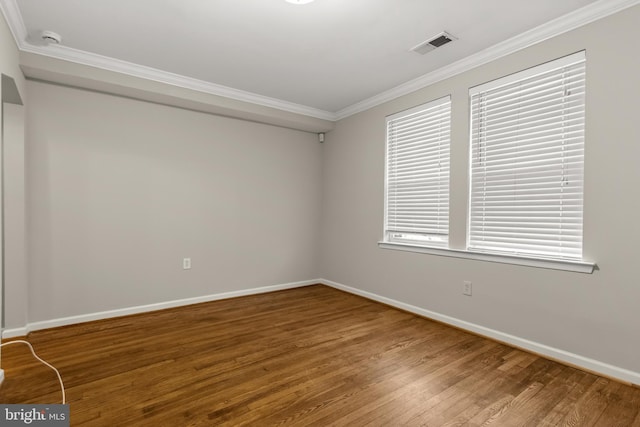 empty room featuring ornamental molding and hardwood / wood-style flooring