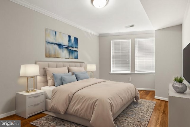 bedroom with wood-type flooring and ornamental molding