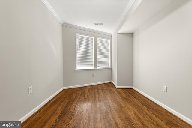 empty room with dark hardwood / wood-style flooring and ornamental molding