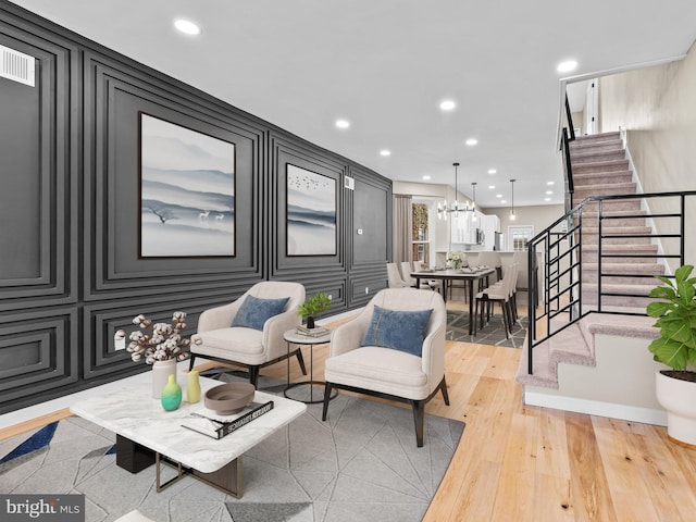 living room with a notable chandelier and light hardwood / wood-style flooring