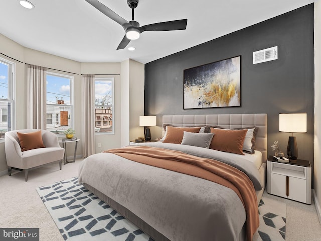 carpeted bedroom featuring ceiling fan and multiple windows