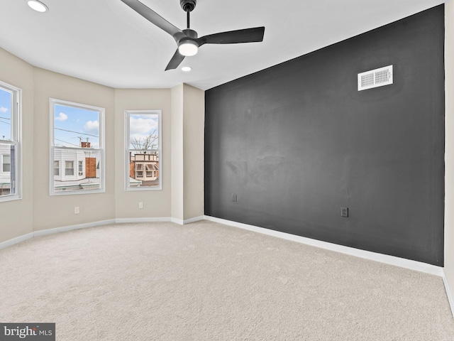 carpeted spare room with ceiling fan