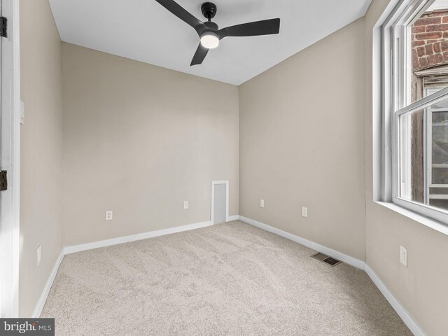 spare room featuring ceiling fan and carpet