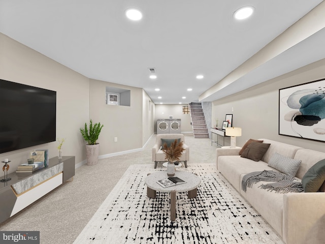 living room featuring washing machine and clothes dryer and light colored carpet