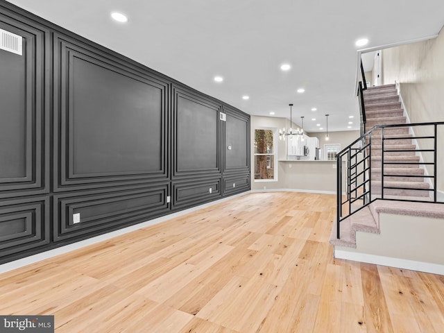 interior space with a notable chandelier and light hardwood / wood-style flooring