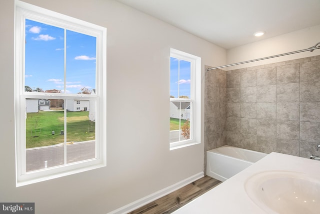 bathroom featuring shower / bathtub combination, wood-type flooring, and sink