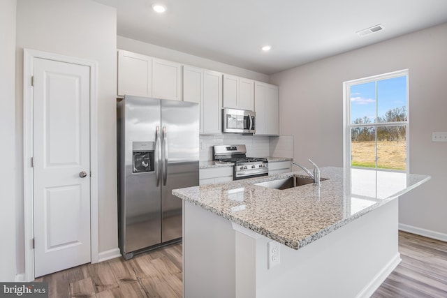 kitchen with white cabinetry, sink, an island with sink, and stainless steel appliances