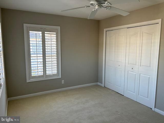 unfurnished bedroom with light carpet, a closet, and ceiling fan