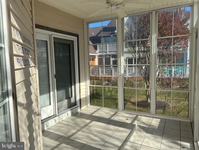 unfurnished sunroom with ceiling fan