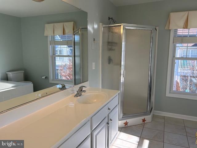 bathroom with toilet, vanity, tile patterned floors, and a shower with door