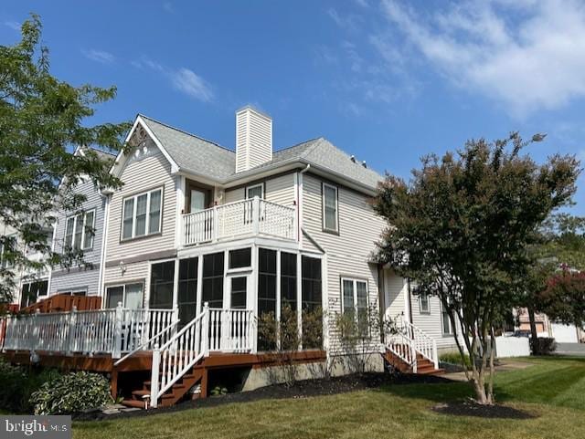 back of house featuring a lawn and a sunroom