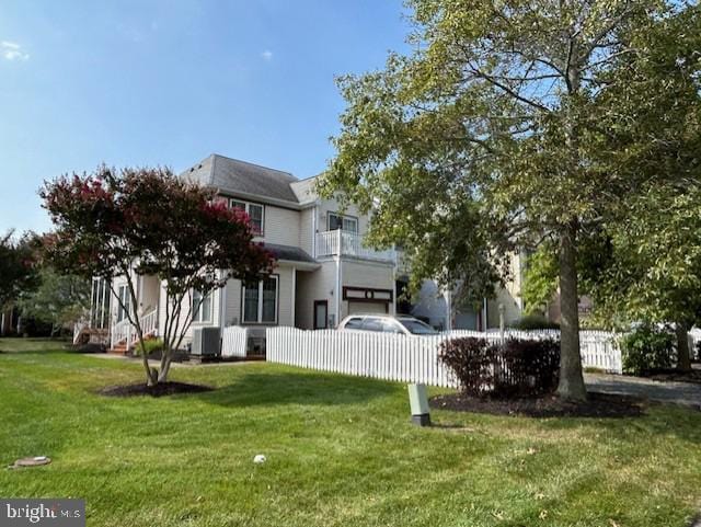 rear view of house with a yard and central AC unit