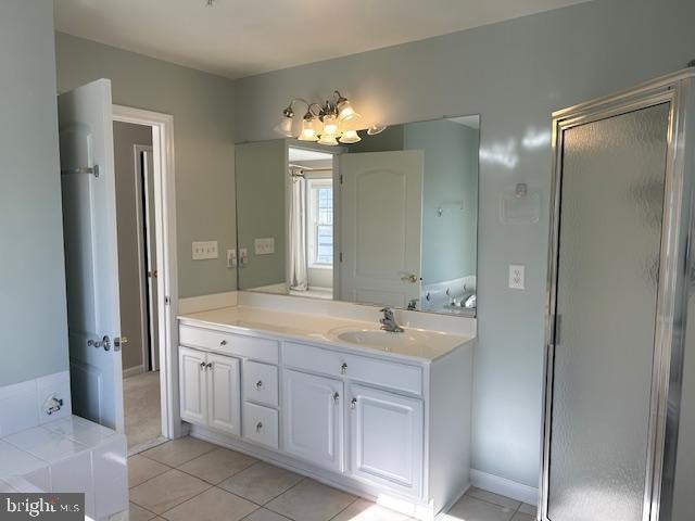 bathroom with tile patterned flooring, vanity, and an enclosed shower