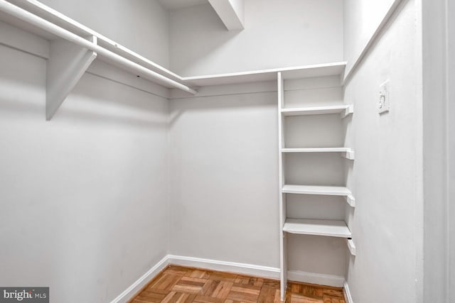 walk in closet featuring parquet flooring