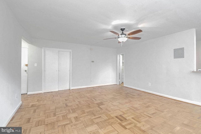 empty room with ceiling fan and light parquet flooring