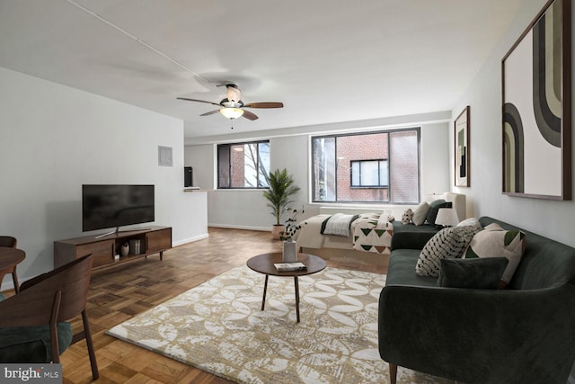 living room featuring ceiling fan and parquet floors