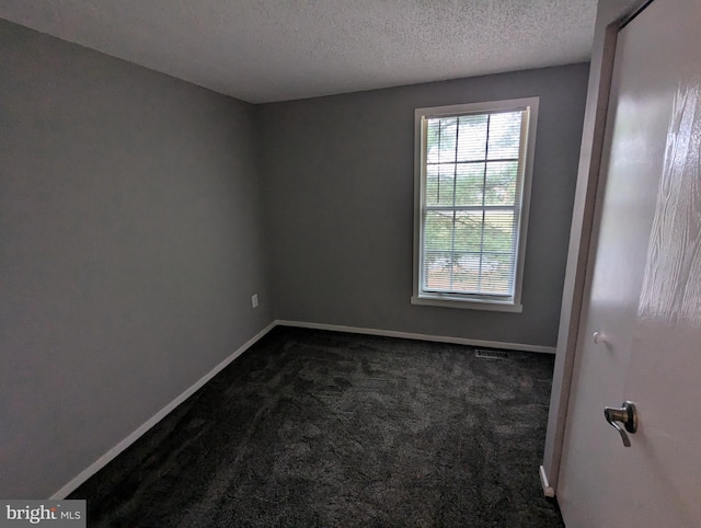 carpeted empty room with a textured ceiling