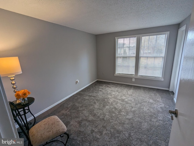 unfurnished room with dark carpet and a textured ceiling