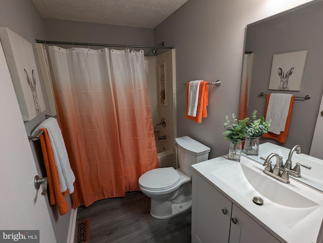 full bathroom featuring vanity, a textured ceiling, shower / bath combo with shower curtain, wood-type flooring, and toilet