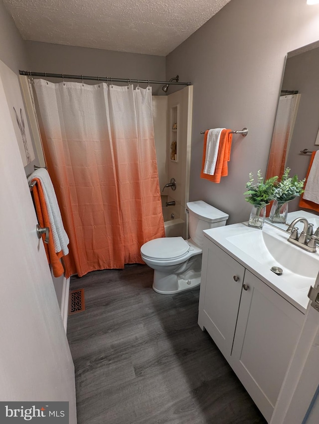 full bathroom featuring a textured ceiling, toilet, shower / tub combo with curtain, vanity, and hardwood / wood-style flooring