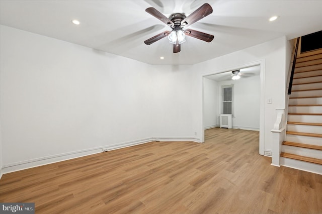 empty room featuring ceiling fan, light hardwood / wood-style flooring, and radiator heating unit