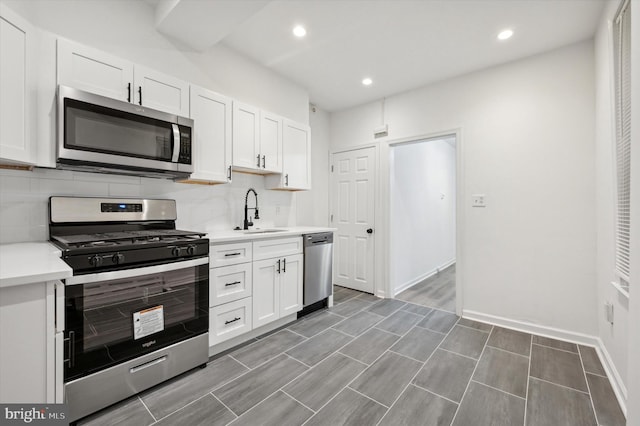 kitchen featuring stainless steel appliances, white cabinetry, and sink