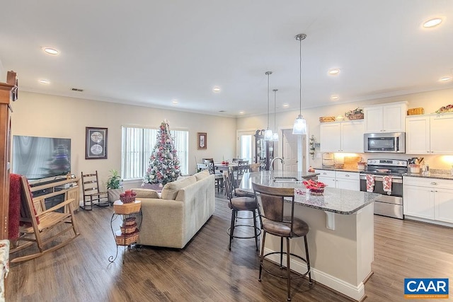 living room with hardwood / wood-style floors, crown molding, and sink