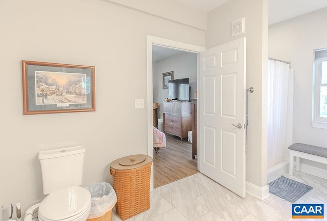 bathroom with curtained shower, hardwood / wood-style flooring, and toilet